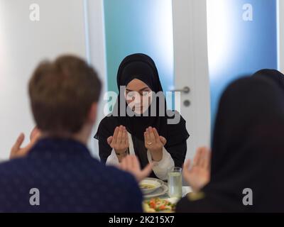 Muslimische Familie macht iftar dua Fasten während Ramadan zu brechen. Stockfoto