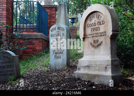 Die Grabsteine und Gräber auf dem gefälschten Friedhof außerhalb der Disney World Haunted Mansion Attraction erzählen Witze und humorvolle Geschichten Stockfoto