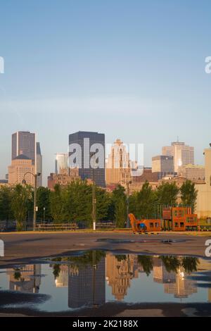 Die Skyline von Montreal spiegelt sich in einer Pfütze aus angesammeltem Regenwasser im alten Hafen von Montreal, Quebec, Kanada. Stockfoto