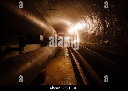 Runder, unterirdischer Betontunnel aus Abwasser, Heizungskanal oder Wasserversorgungssystem Stockfoto