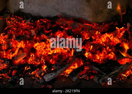 Brennende Kohlen im Feuer. Holzkohle brennt mit rotem Feuer bei hoher Temperatur Stockfoto