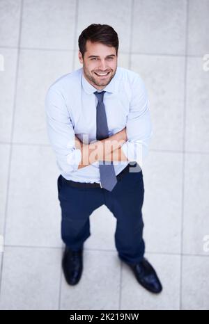 Sein Blick ist hoch. Hochwinkelporträt eines gutaussehenden und selbstbewussten jungen Geschäftsmannes. Stockfoto