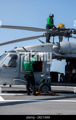 Seeleute, die einem MH-60s Nighthawk zugewiesen wurden, der an den „Tridenten“ des Hubschrauber-Seekampfgeschwaders (HSC) 9 befestigt ist, bereiten sich auf den Flugbetrieb auf dem Flugdeck der USS Gerald R. Ford am 18. September 2022 vor. Ford führt derzeit im Atlantischen Ozean Qualifizierungen von Fluggesellschaften durch und arbeitet für einen geplanten Einsatz im Herbst. (USA Navy Foto von Mass Communication Specialist Seamen Apprentice Daniel Perez) Stockfoto