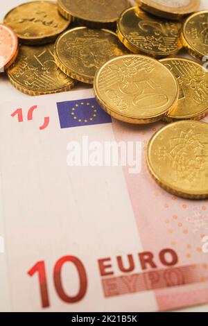 Nahaufnahme von Euro-Münzen auf einer 10-Euro-Banknote. Stockfoto