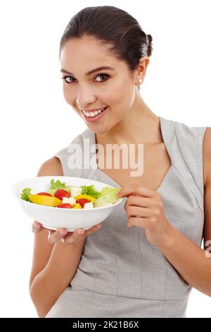 Kein Salatdressing nötig. Studioaufnahme einer attraktiven jungen Frau in eleganter, lässiger Kleidung, isoliert auf Weiß. Stockfoto