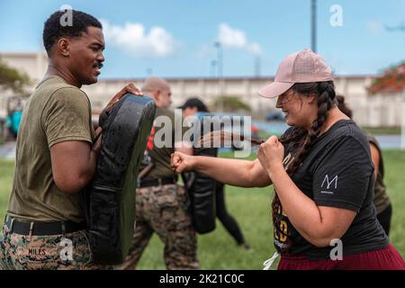 Camp Foster, Okinawa, Japan. 16. September 2022. US Marine Corps Staff Sgt. Tyler Miles, Elektriker bei der Headquarters Company, Combat Logistics Regiment 3, 3. Marine Logistics Group, links, unterrichtet Marinecorps Martial Arts Program Techniques an Trisha Ricketts, einem militärischen Ehepartner, während eines Warrior Day bei Camp Foster, Okinawa, Japan, Septembert. 16, 2022. Der Zweck der Veranstaltung war es, Militärfamilien die Möglichkeit zu geben, Beziehungen untereinander zu bilden und denen, die die Einheit unterstützen, etwas zurückzugeben. 3. MLG aus Okinawa, Japan, ist eine nach vorne eingesetzte Kampfeinheit, die Serv Stockfoto