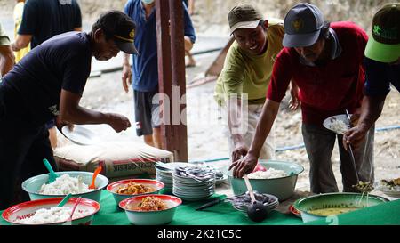 Eine Nahaufnahme von Menschen, die zusammen essen, nachdem sie mit der Zusammenarbeit fertig sind Stockfoto