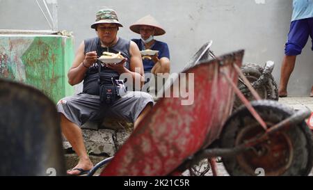 Eine Nahaufnahme von Menschen, die zusammen essen, nachdem sie mit der Zusammenarbeit fertig sind Stockfoto