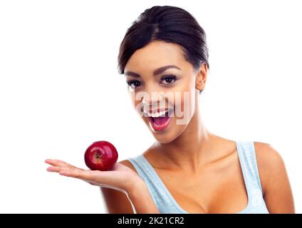 Ein Apfel am Tag wird Wunder für Sie wirken. Eine junge Frau in Turnkleidung, die einen Apfel hält und die Kamera anlächelt. Stockfoto