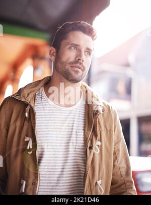 So viele Dinge zu sehen. Ein modischer junger Mann, der durch die Stadt schlendert. Stockfoto