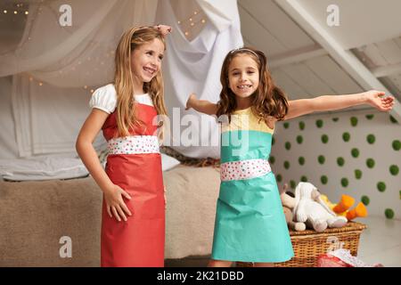 Nun Wow sie mit diesen Kleidern. Portrait von zwei kleinen Mädchen, die in ihren Kleidern aus Papier posieren. Stockfoto