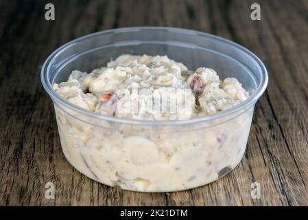 Zum Mittagessen gibt es eine Beilage mit deutschem Kartoffelsalat in einem wiedervernähbaren Behälter. Stockfoto