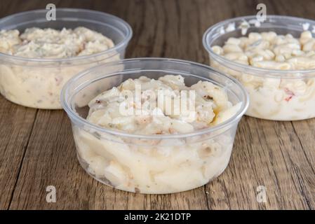 Das Mittagessen wird durch eine Vielzahl von Beilagen ergänzt, die aus Makkaroni, Kartoffel oder deutschem Kartoffelsalat in wiedervernähbaren Behältern bestehen. Stockfoto