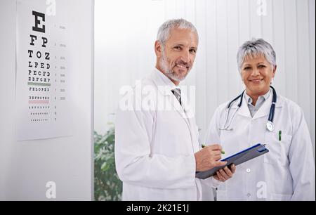 Waren hier, um Ihr Wohlbefinden zu sichern. Porträt zweier Ärzte, die in einem Krankenhaus zusammenarbeiten. Stockfoto