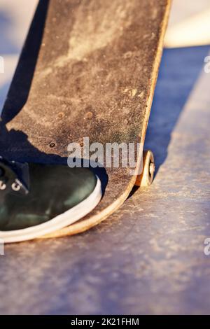 Noch mehr. Nahaufnahme eines Skaters, der auf sein Skateboard tritt. Stockfoto