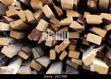 Unschärfe Stapel von Holzbrettern im Sägewerk, Beplankung. Lager zum Sägen von Brettern auf einem Sägewerk im Freien. Holzstapel aus Holzrohlingen konstruieren Stockfoto