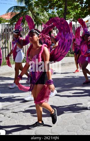 Junge Frauen in geflügelten rosa Kostümen bei der Parade im Karneval von San Pedro, Belize 2022. Stockfoto