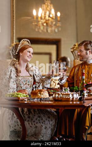 Genießen Sie die Vorteile der königlichen Geburt. Ein königlicher König und eine Königin genießen zusammen ein Essen. Stockfoto