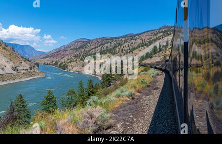 Der Rocky Mountaineer Zug fährt entlang des Fraser River in British Colombia, Kanada. Stockfoto