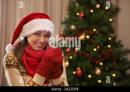 Shes in der Stimmung für Weihnachten. Porträt einer attraktiven jungen Frau, die am Weihnachtsmorgen in ihrem Haus sitzt. Stockfoto