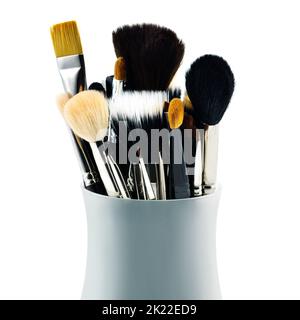 Werkzeuge der Kosmetikbranche. Ein Satz Make-up-Bürsten in ihrem Behälter, isoliert auf Weiß. Stockfoto