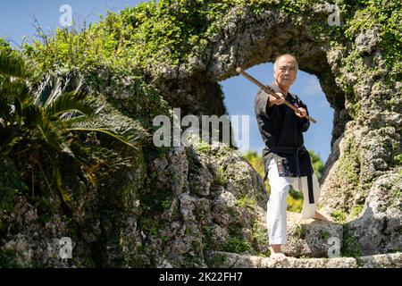 Hidetada Ishiki Sensei 伊敷秀忠先生 Meister von Okinawa Kobudo in den Tamagusku Burgruinen, Chinen, Okinawa. Stockfoto