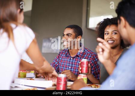 Ein paar Pizza und Getränke. Eine Gruppe von Freunden, die zusammen Pizza genießen. Stockfoto