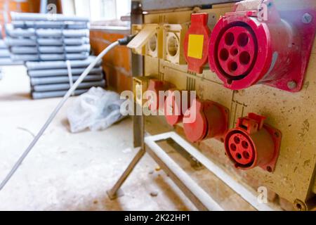 Nahaufnahme des Verteilertabels mit industriellen mehrphasigen Netzsteckern und -Buchsen liefern elektrische Energie für die Baustelle. Stockfoto