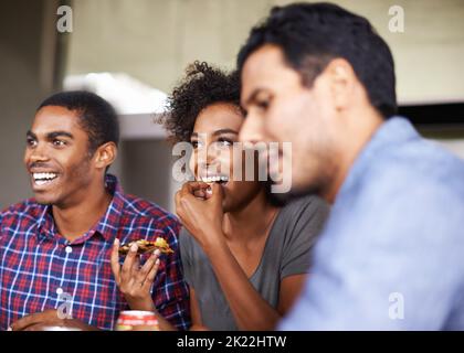 Eine Gruppe von Freunden, die gemeinsam Pizza genießen. Stockfoto
