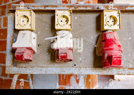 Nahaufnahme des Verteilertabels mit industriellen mehrphasigen Netzsteckern und -Buchsen liefern elektrische Energie für die Baustelle. Stockfoto