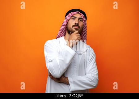 Junger arabischer Mann in traditioneller Kleidung, der an etwas denkt Stockfoto