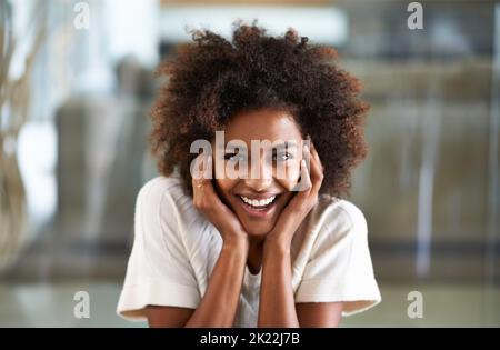 Ihre positive Einstellung ist ansteckend. Porträt einer schönen jungen Frau zu Hause. Stockfoto