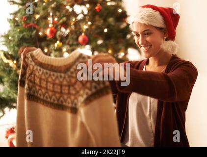 Fast Zeit, die Geschenke auszupacken. Eine junge Frau zu Weihnachten zu Hause. Stockfoto