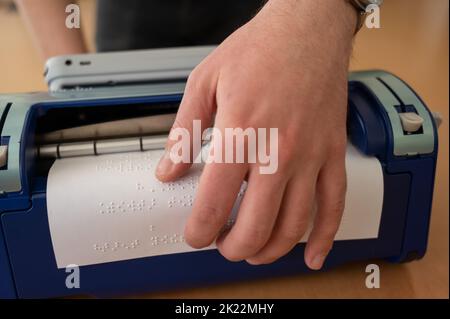 Blinder Mann mit Brailleschrift-Schreibmaschine. Stockfoto