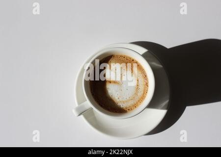 Frisch gebrühter Cappuccino mit Latte Art in Demitasse Cup Closeup. Morgenkaffee. Stockfoto