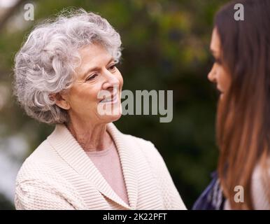 Bewundern der Schönheit ihrer Töchter. Eine ältere Frau verbringt Zeit mit ihrer Tochter im Freien. Stockfoto