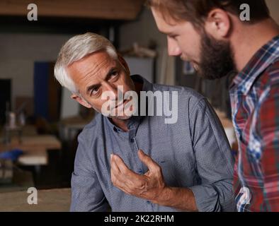 Sein ganzes Wissen weitergeben. Ein älterer Mann, der drinnen steht und seinen Sohn spricht. Stockfoto