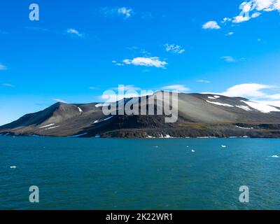 Spektakulärer Panoramablick auf die Insel Wilhelmoya mit Bergkette und blauem Himmel. Torellneset, Nordaustlandet Spitzbergen, Norwegen. Stockfoto