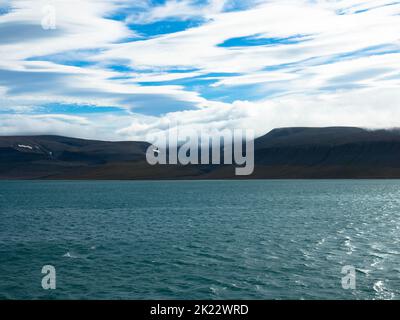 Spektakulärer Panoramablick auf die Insel Wilhelmoya mit Bergkette und blauem Himmel. Torellneset, Nordaustlandet Spitzbergen, Norwegen. Stockfoto