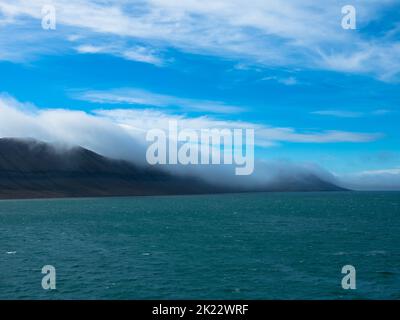 Spektakulärer Panoramablick auf die Insel Wilhelmoya mit Bergkette und blauem Himmel. Torellneset, Nordaustlandet Spitzbergen, Norwegen. Stockfoto