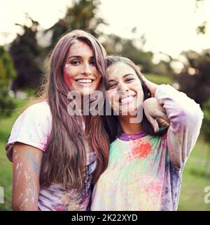 Leben ist Kunst, Leben Sie Ihre in Farbe. Portrait von zwei Freunden, die Spaß auf einem Farbfestival haben. Stockfoto