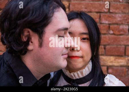 Porträt eines asiatischen Mädchens mit einem halben Gesicht, bedeckt von einem kaukasischen Jungen, Konzept der Integration und multiethnischen Gesellschaft Stockfoto