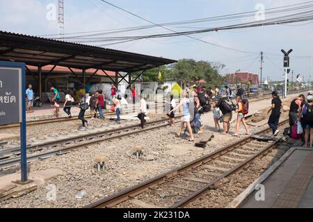 Passagiere, die die Gleise überqueren, nachdem sie am Bahnhof in Ayutthaya Thailand angekommen sind Stockfoto