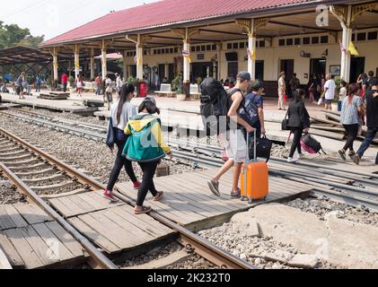 Passagiere, die die Gleise überqueren, nachdem sie am Bahnhof in Ayutthaya Thailand angekommen sind Stockfoto