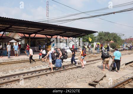 Passagiere, die die Gleise überqueren, nachdem sie am Bahnhof in Ayutthaya Thailand angekommen sind Stockfoto