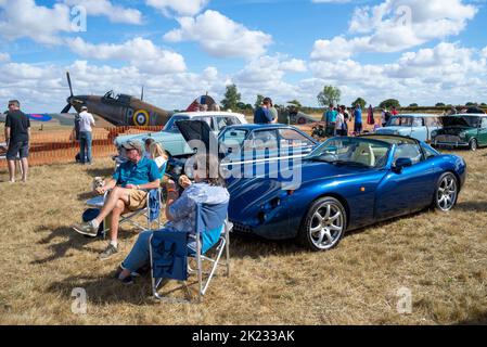 Autos auf der Little Gransden Air and Car Show, Bedfordshire, Großbritannien. TVR toskanischer Sportwagen und Oldtimer von Hawker, einem Kampfflugzeug des 2. Weltkriegs, dem „Hikan“-Jagdflugzeug des Stockfoto