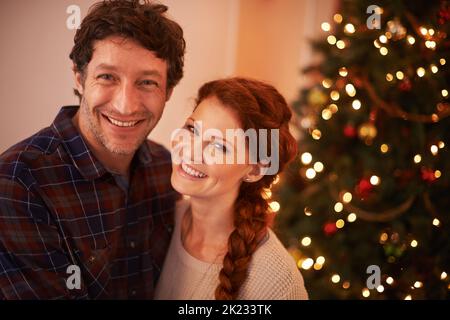 Du bist das einzige Geschenk, das ich brauche. Porträt eines liebevollen Paares in ihrem Zuhause zur Weihnachtszeit. Stockfoto