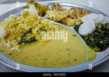 Kadi - Chawal oder Joghurt-Kururthali. Nordindische Speiseplatte. Reis, Salat und Omelette. Uttarakhand Indien Stockfoto