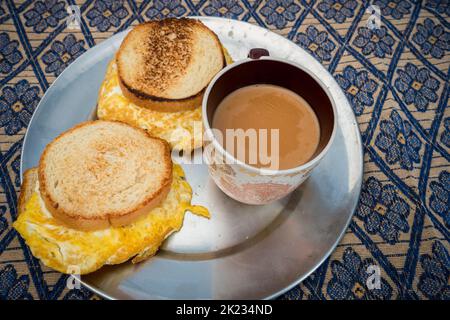 Gegrilltes Knoblauchbrot Omelett Sand Hexe mit Tee. Uttarakhand, Indien. Stockfoto