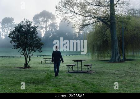 Frau, die im Nebel in einem Park läuft Stockfoto